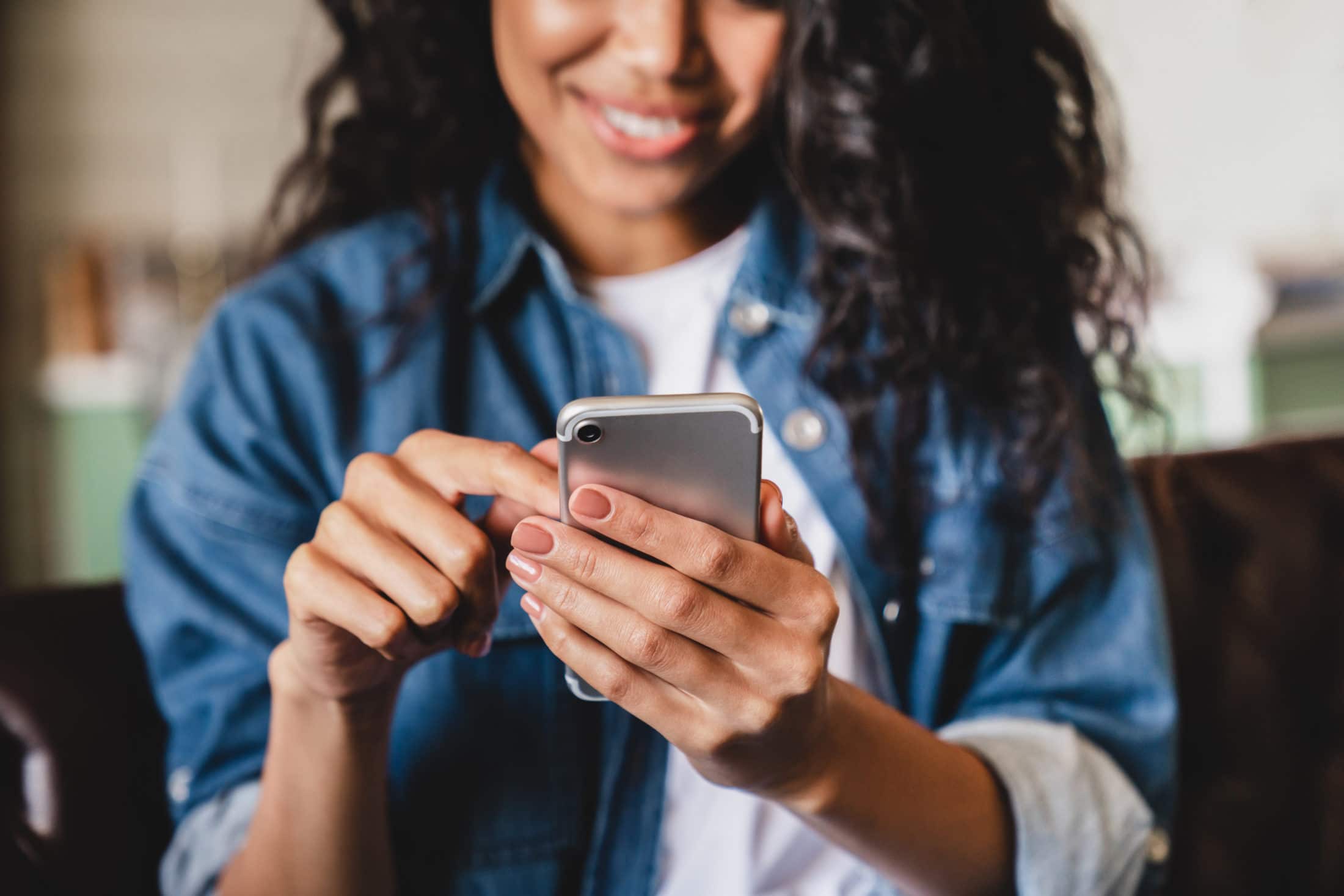 young woman of color using a smartphone to communicate